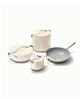 Caraway 8-piece non-stick cookware set in cream.